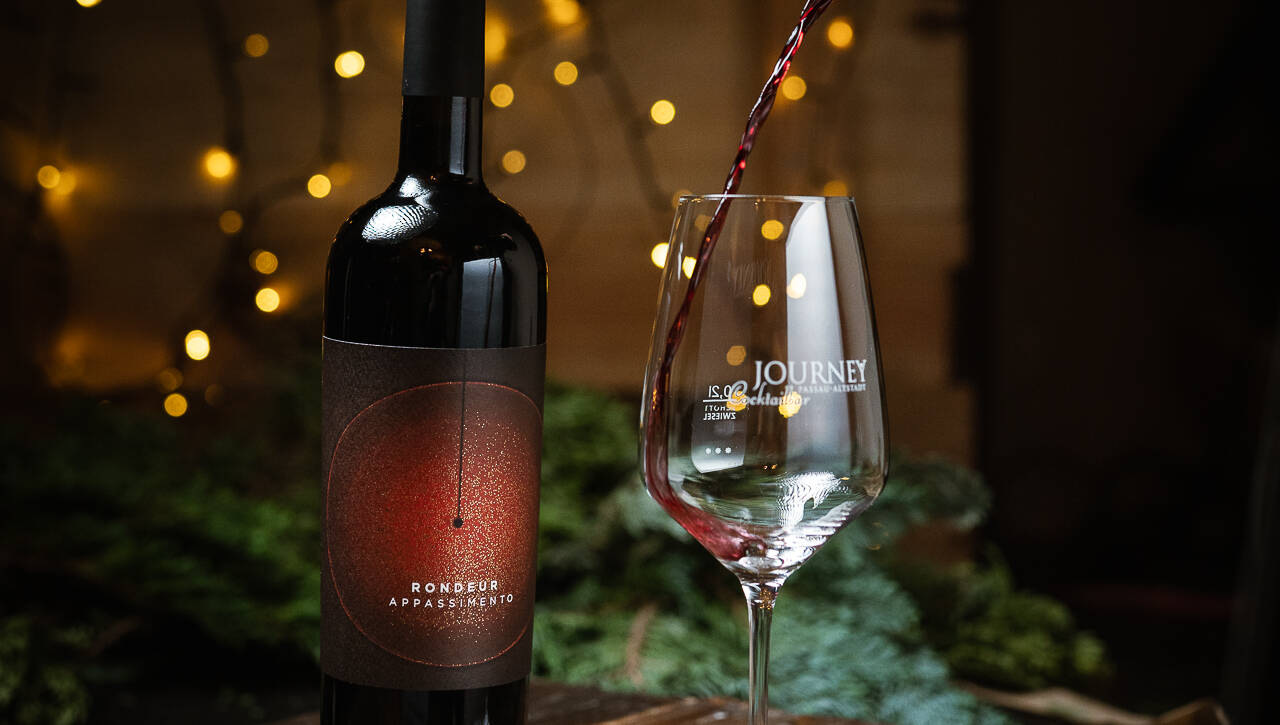 Weinflasche und Glas mit weihnachtlichem Hintergrund und Pralinen